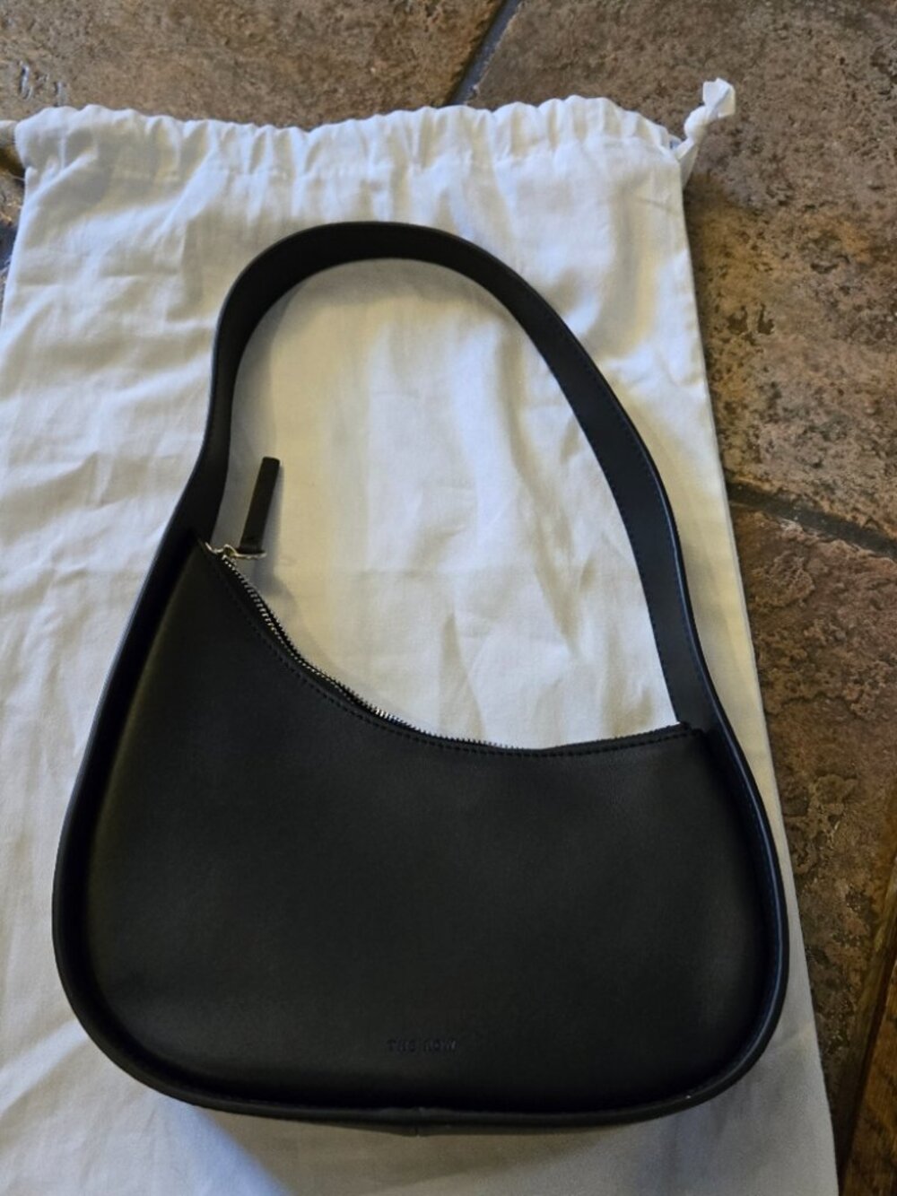 The Row Half Moon Black Leather Shoulder Bag with Wide Strap and Top Zip Closure